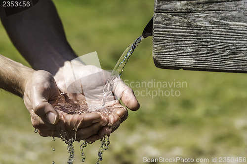 Image of Thirsty Hands taking water from well