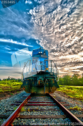 Image of blue freight train engine at sunrise 