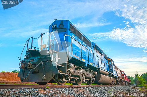 Image of blue freight train engine at sunrise 