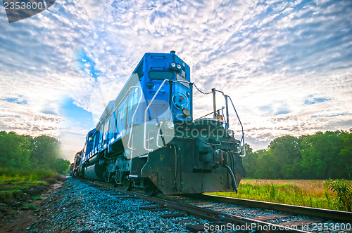 Image of blue freight train engine at sunrise 