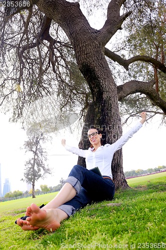 Image of Beautiful young woman with  tablet in park