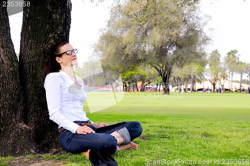 Image of Beautiful young woman with  tablet in park