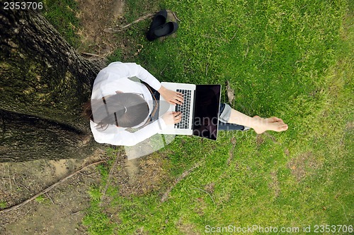 Image of woman with laptop in park