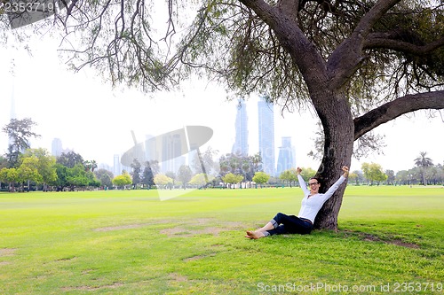 Image of Beautiful young woman with  tablet in park