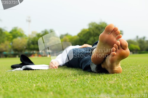 Image of Young woman reading a book in the park