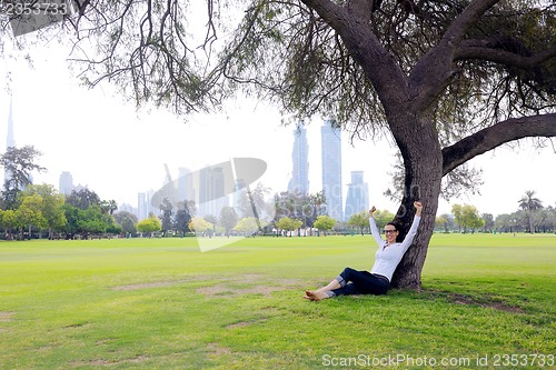 Image of Beautiful young woman with  tablet in park