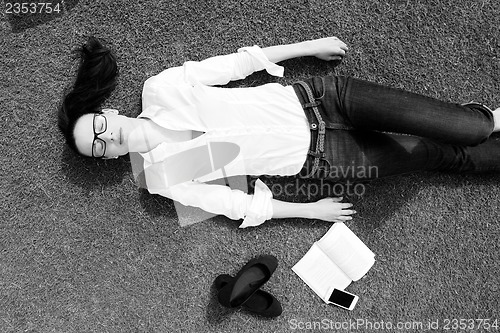 Image of Young woman reading a book in the park