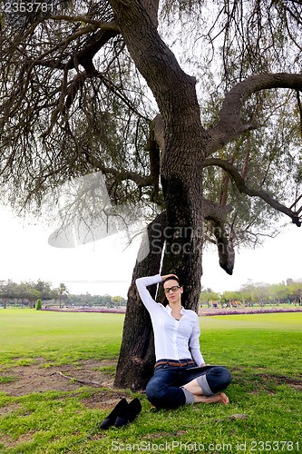 Image of Beautiful young woman with  tablet in park