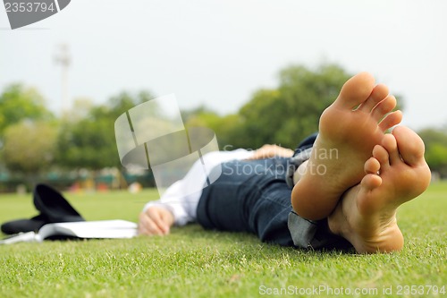 Image of Young woman reading a book in the park