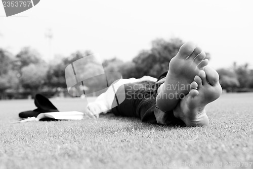 Image of Young woman reading a book in the park