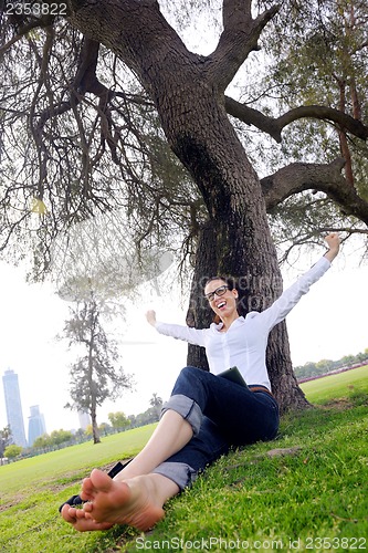 Image of Beautiful young woman with  tablet in park
