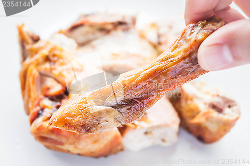 Image of Close up grilled chicken leg on hand 