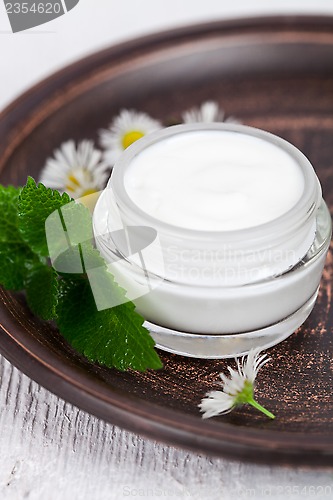 Image of container with cream urtica and chamomiles 