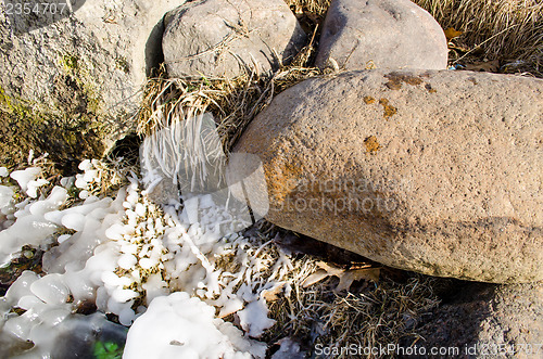 Image of large stones lit icy grass 