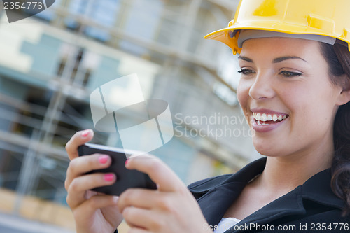 Image of Female Contractor Wearing Hard Hat on Site Texting with Phone