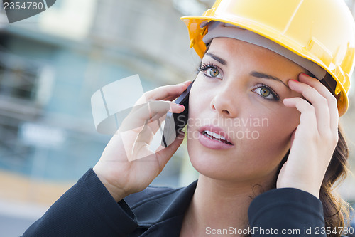 Image of Worried Female Contractor Wearing Hard Hat on Site Using Phone