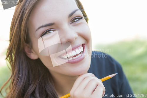 Image of Portrait of Pretty Young Female Student with Pencil on Campus