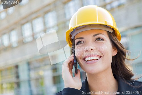 Image of Young Female Contractor Wearing Hard Hat on Site Using Phone