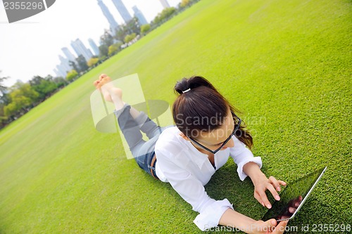 Image of Beautiful young woman with  tablet in park