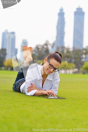 Image of Beautiful young woman with  tablet in park