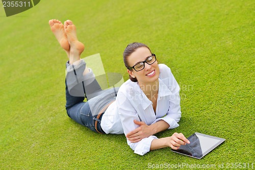 Image of Beautiful young woman with  tablet in park