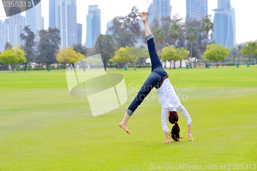 Image of young woman jumping in park