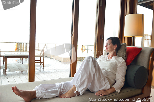 Image of happy young woman relax at home on sofa