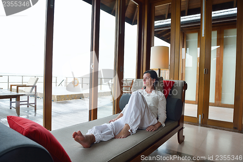 Image of happy young woman relax at home on sofa