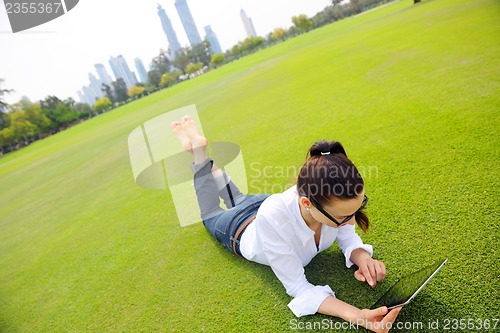 Image of Beautiful young woman with  tablet in park