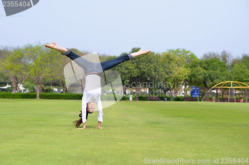 Image of young woman jumping in park