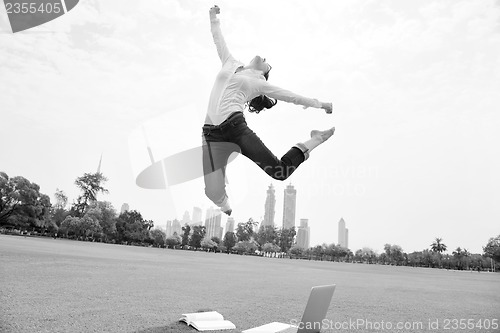 Image of young woman jumping in park