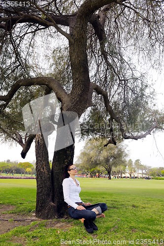 Image of Beautiful young woman with  tablet in park