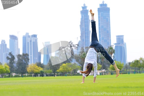 Image of young woman jumping in park