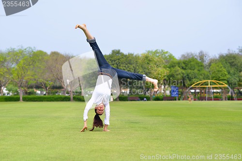 Image of young woman jumping in park