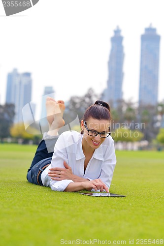 Image of Beautiful young woman with  tablet in park