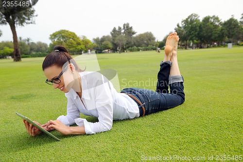 Image of Beautiful young woman with  tablet in park