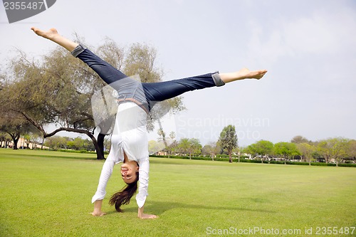 Image of young woman jumping in park