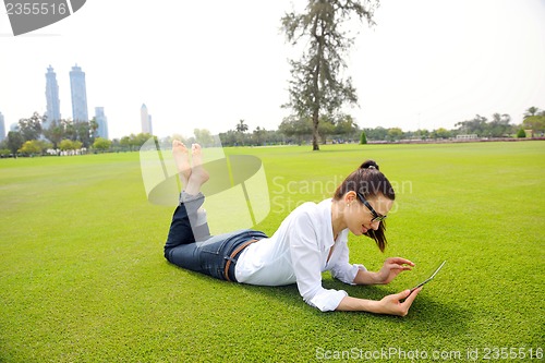 Image of Beautiful young woman with  tablet in park