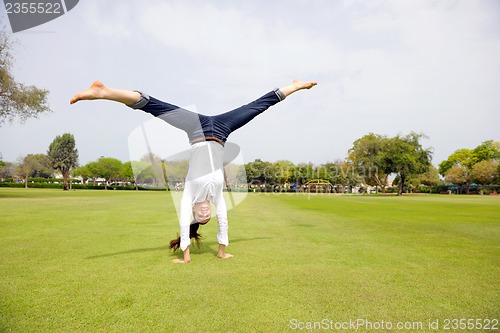 Image of young woman jumping in park