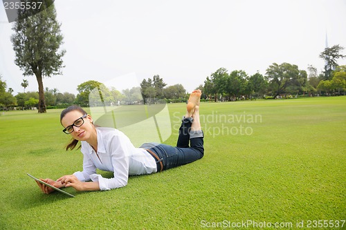 Image of Beautiful young woman with  tablet in park