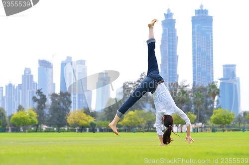 Image of young woman jumping in park