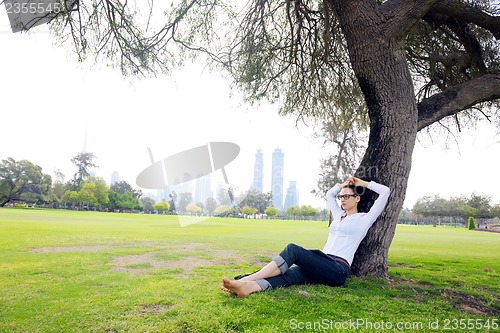 Image of Beautiful young woman with  tablet in park