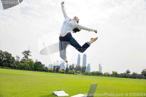 Image of young woman jumping in park