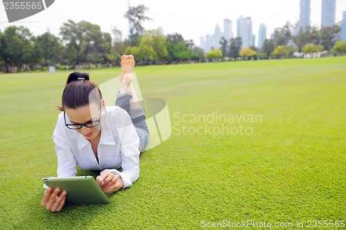 Image of Beautiful young woman with  tablet in park