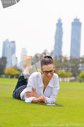 Image of Beautiful young woman with  tablet in park