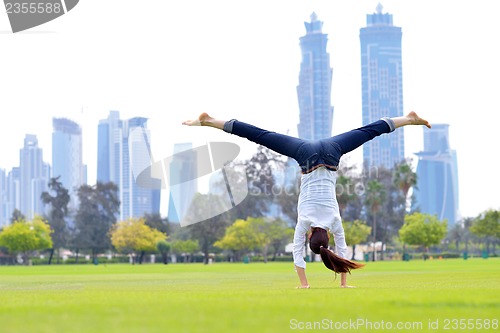 Image of young woman jumping in park