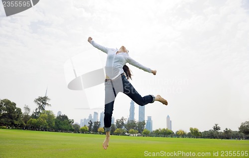 Image of young woman jumping in park