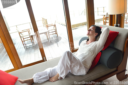 Image of happy young woman relax at home on sofa