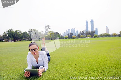 Image of Beautiful young woman with  tablet in park