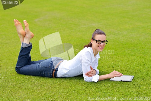 Image of Beautiful young woman with  tablet in park